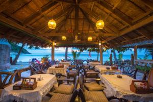 a restaurant with tables and chairs on the beach at Bottle Beach 1 Resort in Bottle Beach