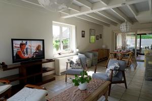 uma sala de estar com uma televisão de ecrã plano e um sofá em Vakantiehuis Zand en Zee in Oostduinkerke aan zee em Oostduinkerke