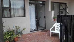 a white chair sitting on a patio outside of a house at Self-catering Studio, Unit 6 on Krupp in Windhoek