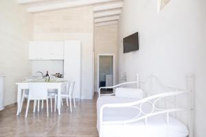 Masseria 25 Anni في لاتيرزا: غرفة معيشة بيضاء مع طاولة وكراسي بيضاء