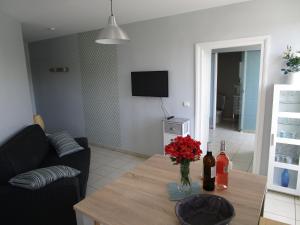 a living room with a table with red flowers on it at Agréable T2 à Bidart, centre bourg & plages à pied in Bidart