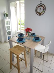 a dining room table and chairs with a clock on the wall at Agréable T2 à Bidart, centre bourg & plages à pied in Bidart