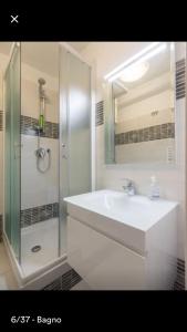een witte badkamer met een wastafel en een douche bij Mansarda In Borgo Dora in Turijn