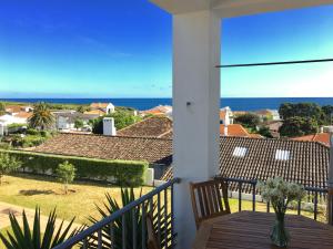 Un balcón con mesa y vista al mar. en Casa do O, en Ponta Delgada