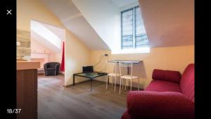 een woonkamer met een rode bank en een tafel bij Mansarda In Borgo Dora in Turijn