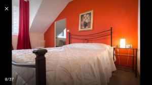 トリノにあるMansarda In Borgo Doraのベッドルーム1室(オレンジ色の壁のベッド1台付)
