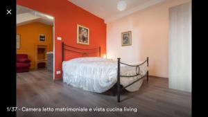 トリノにあるMansarda In Borgo Doraのベッドルーム1室(オレンジ色の壁のベッド1台付)