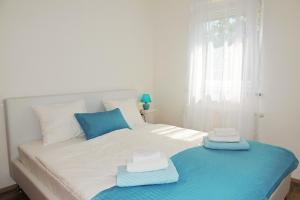 a white bed with two towels on top of it at Private accommodation KIRINCIC in Vrh