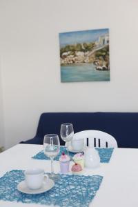 カステッランマーレ・デル・ゴルフォにあるCorallo Bluのワイングラス2杯とカップケーキ付きのテーブル
