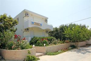 a building with flowers and plants in front of it at DM Apartments in Rethymno