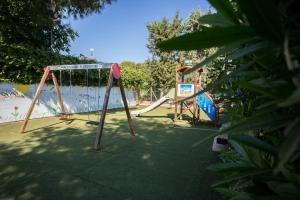 two swings in a park next to a beach at Tenuta del Barco WineRestaurant and Hospitality in Pulsano
