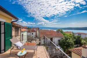 balkon z krzesłem i widokiem na wodę w obiekcie Holiday House Kate w mieście Čižići