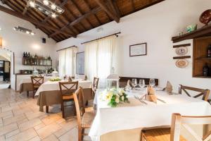 a large dining room with white tables and chairs at Tenuta del Barco WineRestaurant and Hospitality in Pulsano