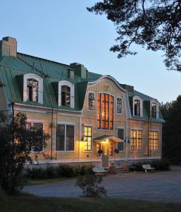 a large house with a green roof at Mäntyluodon Hotelli in Pori