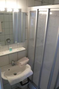 a bathroom with a sink and a shower at Landgasthof Schützenhof Artlenburg in Artlenburg