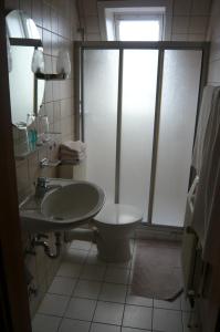 a bathroom with a sink and a toilet and a window at Landgasthof Schützenhof Artlenburg in Artlenburg