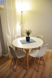 stół z krzesłami i doniczką w obiekcie Apartament Aneta w Warszawie