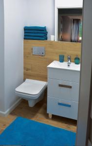 Łazienka z białą toaletą i umywalką w obiekcie Apartament Aneta w Warszawie