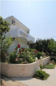a building with a flower garden in front of it at DM Apartments in Rethymno