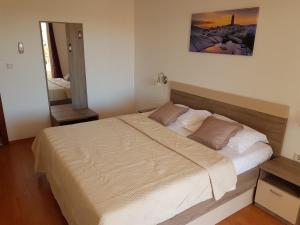 een slaapkamer met een groot bed in een kamer bij Pansion Marco Polo in Petrcane