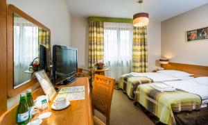 ein Hotelzimmer mit 2 Betten und einem Schreibtisch in der Unterkunft Hotel City SM Business & Spa in Krakau