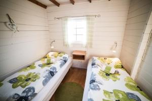 2 Betten in einem kleinen Zimmer mit Fenster in der Unterkunft Geysir Hestar in Haukadalur