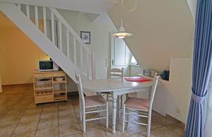 a dining room with a table and chairs and a staircase at Haus-Meisennest-Wohnung-Eule in Westerland (Sylt)