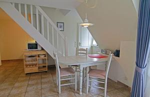 a dining room with a table and chairs and a staircase at Haus-Meisennest-Wohnung-Eule in Westerland