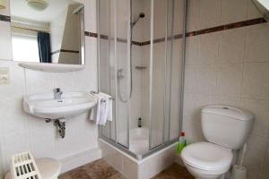 a bathroom with a shower and a toilet and a sink at Haus-Meisennest-Wohnung-Eule in Westerland