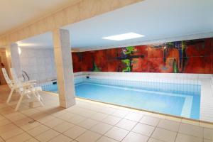 a swimming pool in a house with a painting on the wall at Haus-Meisennest-Wohnung-Eule in Westerland