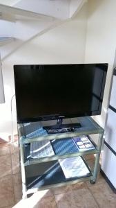 einen TV auf einem Glasregal in einem Zimmer in der Unterkunft Haus Meisennest, Wohnung Amsel in Westerland