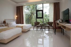 a hotel room with two beds and a desk at One El Nido Suite in El Nido
