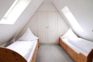 2 Betten in einem Dachzimmer mit Oberlichtern in der Unterkunft Haus Meisennest, Wohnung Adler in Westerland