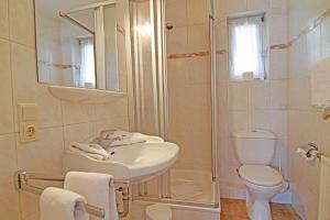 ein weißes Bad mit einem Waschbecken und einem WC in der Unterkunft Haus Meisennest, Wohnung Adler in Westerland