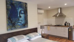 a bedroom with a large painting on the wall at Alaya Ascend in Eudlo