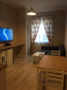 sala de estar con TV y mesa en Apartament Romantic, en Oświęcim