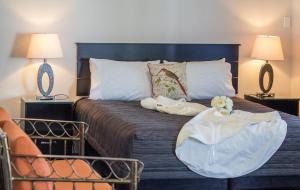 a bedroom with a large bed with two lamps at Greyfriars Motel in Greytown