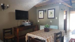 a dining room with a table and a television at Warembo Lodge in Grootvlei
