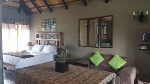 a bedroom with a bed and a couch and mirrors at Warembo Lodge in Grootvlei