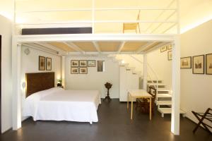 a bedroom with a white bed and a staircase at Sopra il Limoneto in Cetara
