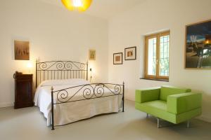 a bedroom with a bed and a green chair at Sopra il Limoneto in Cetara