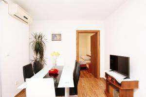 ein Wohnzimmer mit einem Tisch und einem TV in der Unterkunft Apartment Anica in Trogir