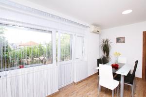 Cette chambre blanche dispose d'une table et d'une fenêtre. dans l'établissement Apartment Anica, à Trogir