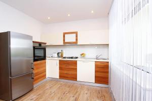 eine Küche mit einem Kühlschrank aus Edelstahl und Holzschränken in der Unterkunft Apartment Anica in Trogir
