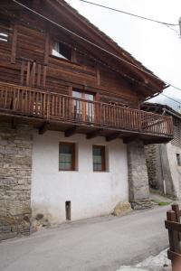 a wooden house with a balcony on the side of it at Bellavista Cogne Apartment in Cogne