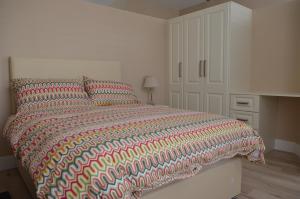 a bedroom with a large bed with a colorful comforter at Blessings Studio Apartments in Cootehill