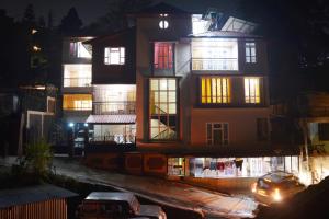 um edifício com um carro estacionado em frente dele à noite em Kashyap Kunj em Gangtok