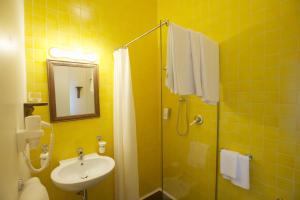 a yellow bathroom with a sink and a shower at Sopra il Limoneto in Cetara