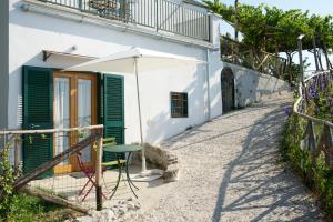 a table and an umbrella in front of a house at Sopra il Limoneto in Cetara