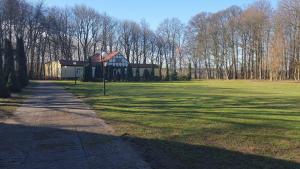 una casa en medio de un campo verde en Hostel Dworek Osiecki KORAL, en Osieki